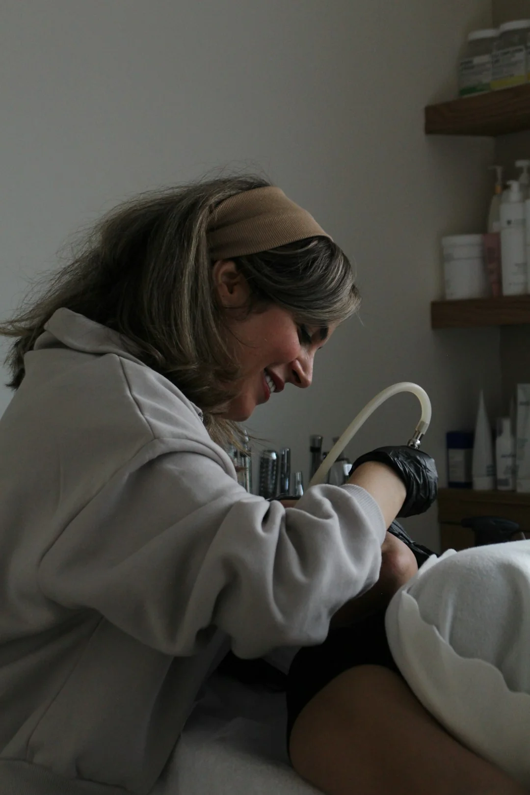 A cleaner in protective coveralls and gloves vacuuming a modern living room.