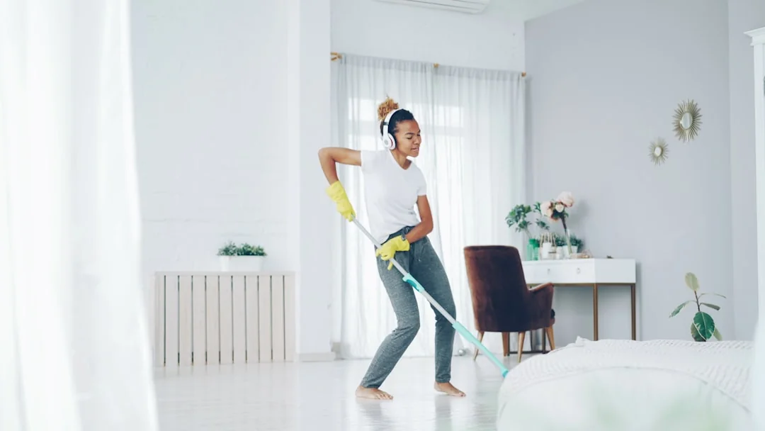 Man cleans floor at an entrance door.